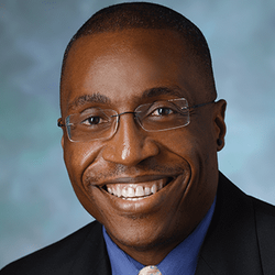 Headshot of KL2 Scholar Dr. Chukwuemeka Ihemelandu. He is smiling and wearing glasses.